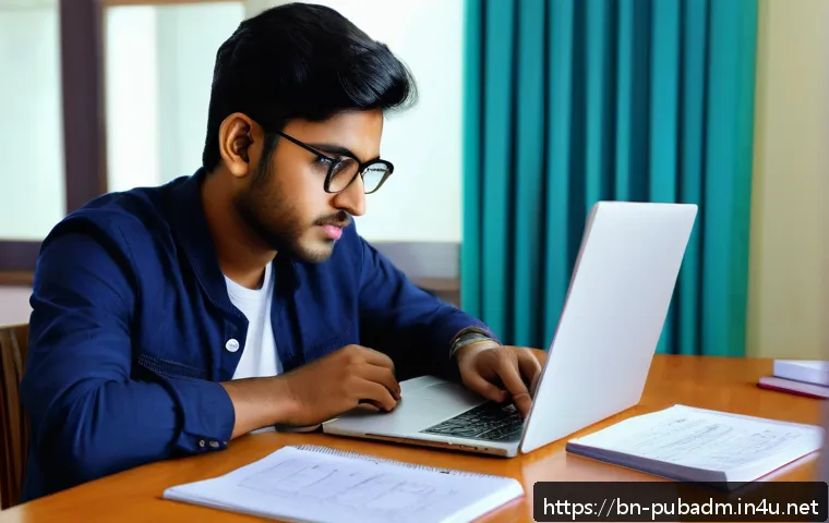 공공부문 직무와 경력 개발 - A focused young Bengali man studying government job exam syllabus at a modern desk with a laptop, of...